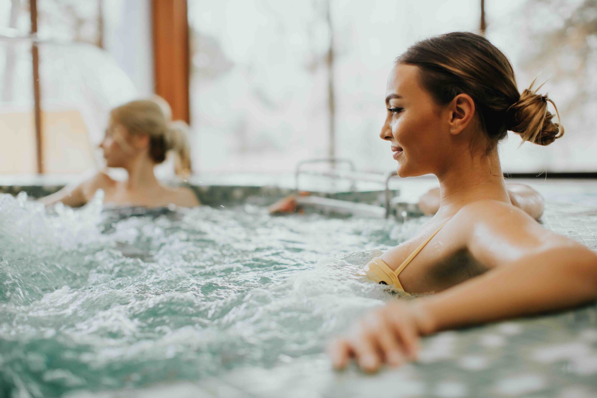 Pretty young woman relaxing in the whirlpool bathtub